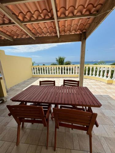 a wooden table and benches on a patio at Las Palmeras by Graziano in Boca Chica