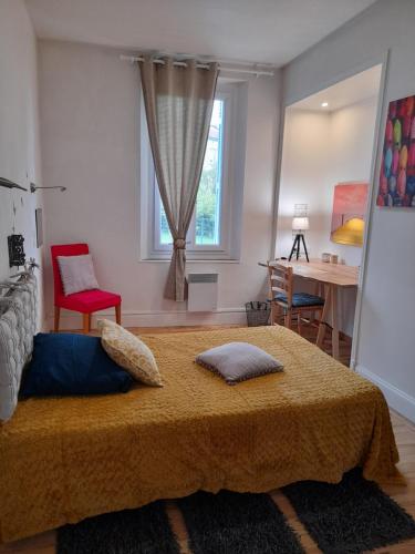 Schlafzimmer mit einem Bett, einem Tisch und einem Fenster in der Unterkunft Pamiers gare - 2 Appartements à louer ou Chambre parentale indépendante in Pamiers