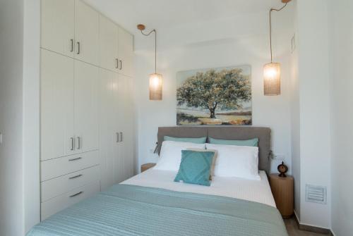 a bedroom with a bed with white cabinets at aerie home Skyros in Skiros