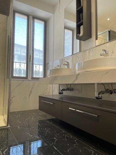 een badkamer met 2 wastafels en een grote spiegel bij Appartamento "Da Maddalena" in Menaggio
