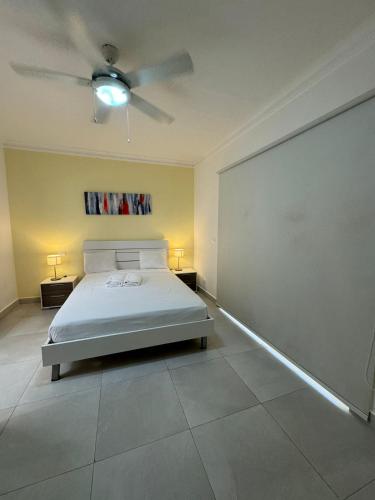 a bedroom with a bed and a ceiling fan at Las Palmeras by Graziano in Boca Chica