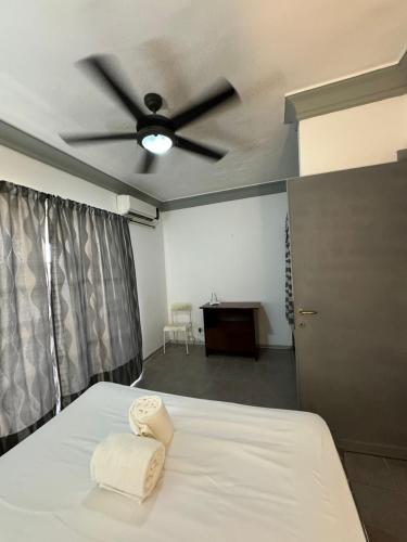 a bedroom with a bed with a ceiling fan at Las Palmeras by Graziano in Boca Chica