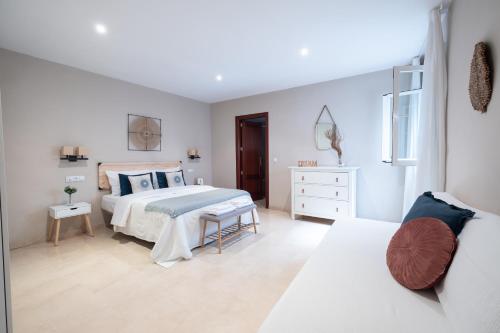 a white bedroom with a bed and a couch at Apartamento céntrico Rincón de Ensueño Parking gratis in Jaén