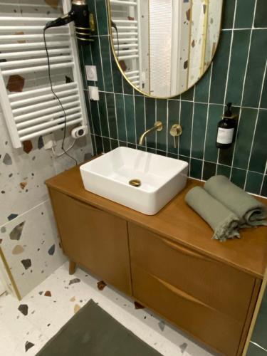 a bathroom with a white sink and a mirror at La Halte des Arènes de Nîmes Emeraude, Havre de paix en ville in Nîmes