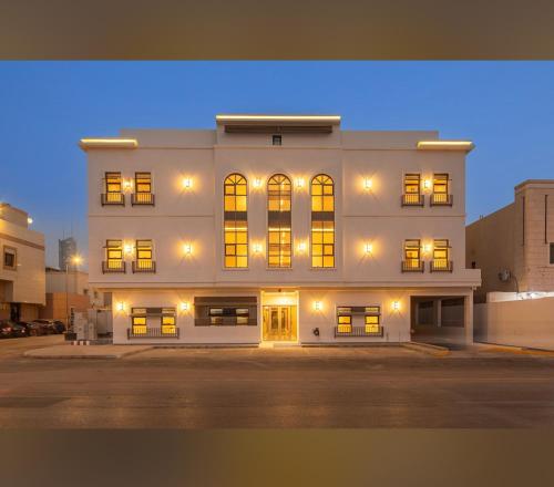 リヤドにあるLuxury condo in almalqa near Boulevardの夜間の照明付き窓のある白い大きな建物