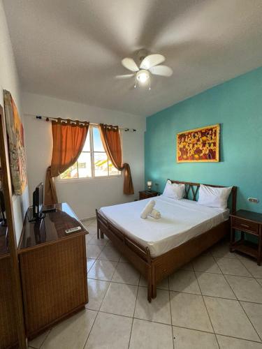 a bedroom with a bed and a ceiling fan at Las Palmeras by Graziano in Boca Chica