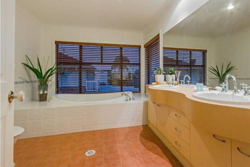 a bathroom with a tub and a sink and a bath tub at Bliss On Sunshine in Gold Coast