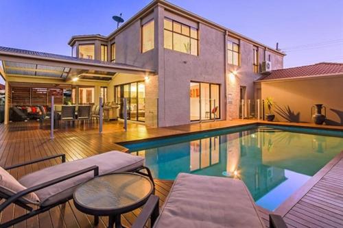 a house with a swimming pool in front of a house at Bliss On Sunshine in Gold Coast