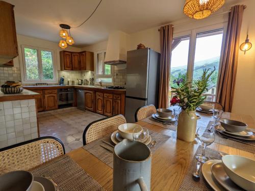 une cuisine et une salle à manger avec une table en bois et des chaises dans l'établissement La Bigourdane Grand gîte confortable & Spa, à Campan