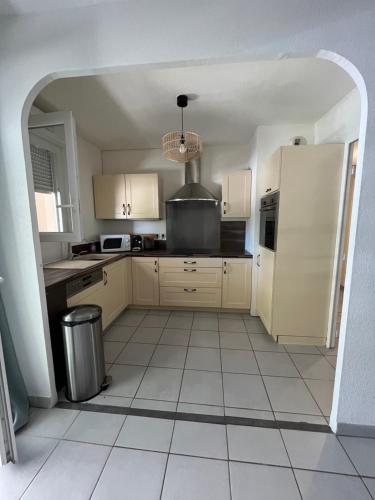 Il comprend une cuisine avec des placards blancs et du carrelage blanc. dans l'établissement YT COSY, à Avignon