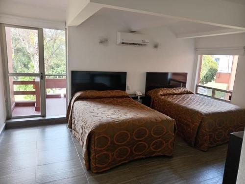 Una habitación de hotel con dos camas y una ventana. en HOTEL PUNTA GALERIA, en Morelia