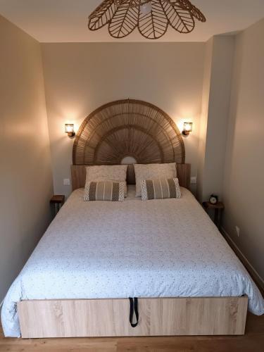 une chambre avec un grand lit avec une tête de lit en bois dans l'établissement Appartement l'Embarcadère, à Boulogne-sur-Mer