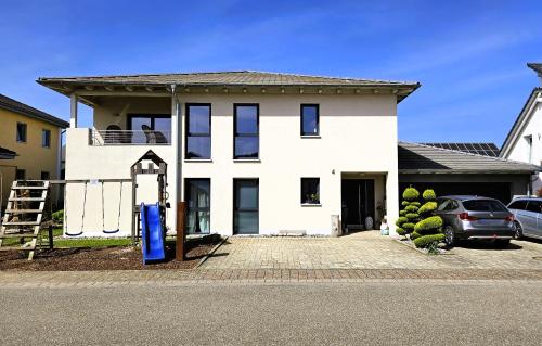 a white house with a car parked in front of it at Gästehaus Ferienwohnung Abendstern in Rust