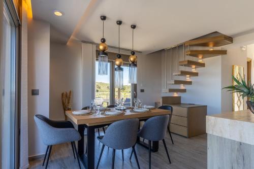a dining room with a wooden table and chairs at Rhode Luxury Villa in Kalithies