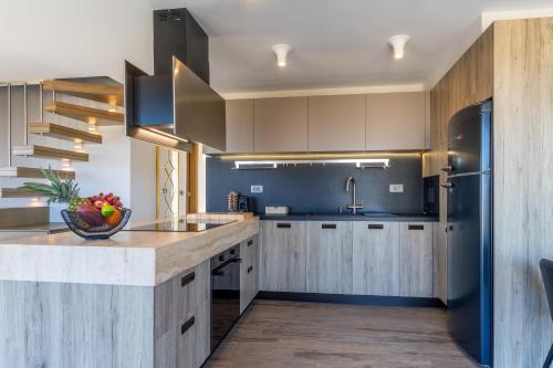 a kitchen with wooden cabinets and a counter top at Rhode Luxury Villa in Kalithies