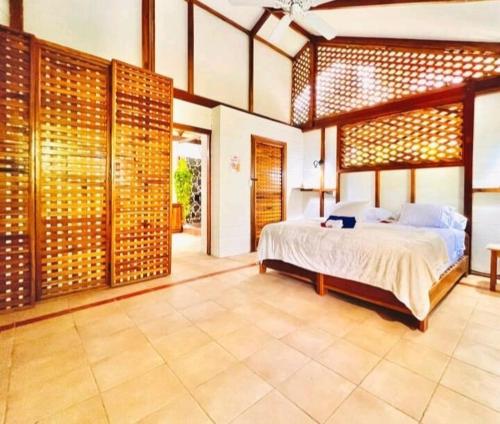 um quarto com uma cama grande num quarto em Casa Elita - Tranquil Escape with Pool, Jacuzzi, AC em Puerto Viejo
