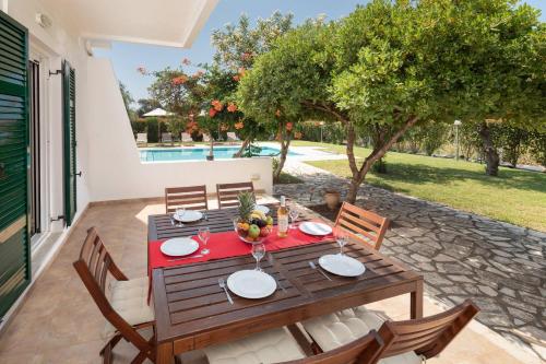 a wooden table and chairs on a patio at Skales Villas in Almiros Beach
