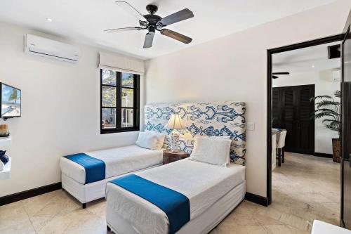 a bedroom with two beds and a ceiling fan at Stylish Beach-Themed Condo with Two Bedrooms and Lovely Ocean Views in Playa Danta
