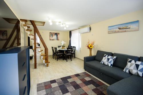 - un salon avec un canapé et une salle à manger dans l'établissement Emili Apartman Ráckeve, à Ráckeve