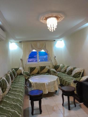 a living room with green couches and a table at Marwan's apartment Ifrane Gardens in Ifrane