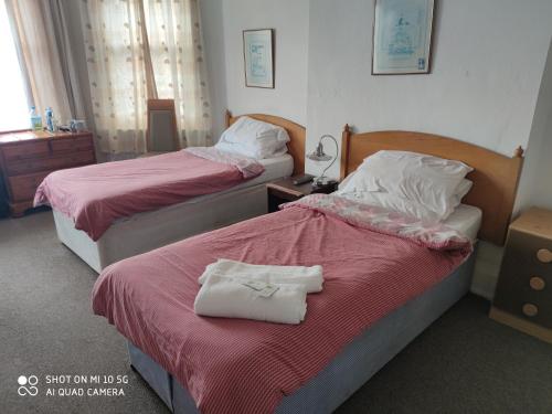 斯勞的住宿－Sussex Lodge Guest House，两张位于酒店客房的床,配有毛巾