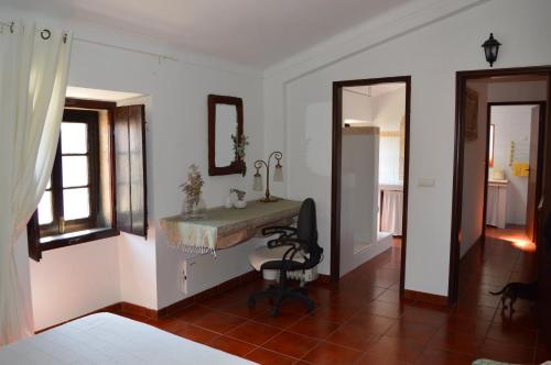 a bedroom with a desk and a mirror and a chair at Sunday every Day in Olho Marinho