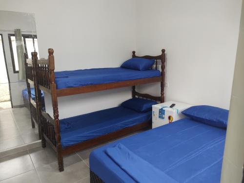 Habitación con 2 literas y almohadas azules. en Casa Cardoso en Bertioga