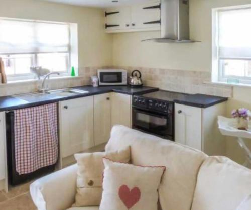 a living room with a couch and a kitchen at Beech cottage ~ close to York ~ cozy rural stay in Stamford Bridge