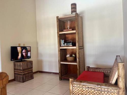 a living room with a tv in the corner of a room at Apart super bem localizado perto de tudo! in Ilhéus