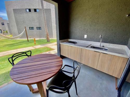 einen Tisch und Stühle sowie ein Waschbecken im Zimmer in der Unterkunft Villas Manatee Milagres C006 in Pôrto de Pedras