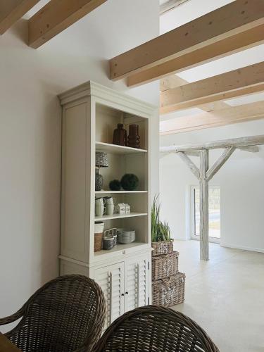 a dining room with two chairs and a book shelf at Sievershof Poolloft in Wietzendorf