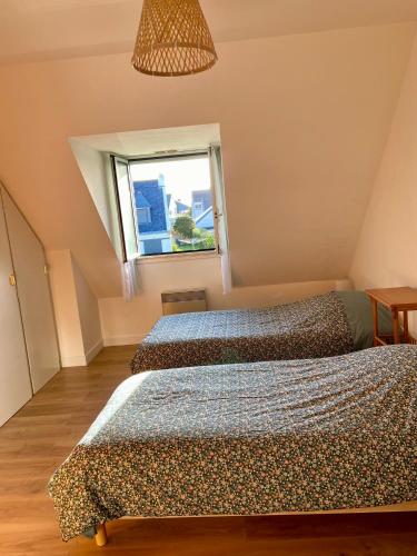 deux lits dans une chambre avec une fenêtre dans l'établissement Maison Chapeau Saint Jacques - 400m de la plage, à Sarzeau
