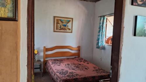 ein kleines Schlafzimmer mit einem Bett und einem Fenster in der Unterkunft Hostel Vila Mamulengo in Alexânia