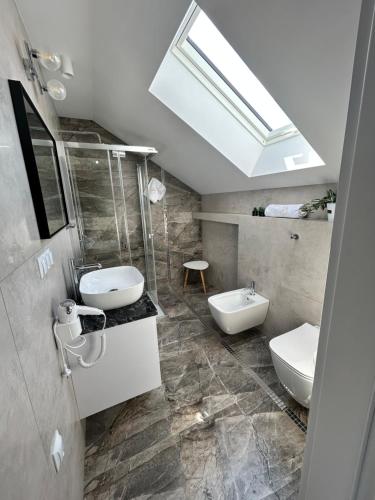 a bathroom with two toilets and a skylight at Wiktoria Residence Krynica-Zdrój in Krynica Zdrój