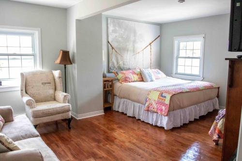 a bedroom with a bed and a chair at The Jypsy Inn - Journey Apartment Muskoka in Bracebridge