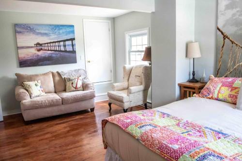 a bedroom with a bed and a couch and a chair at The Jypsy Inn - Journey Apartment Muskoka in Bracebridge