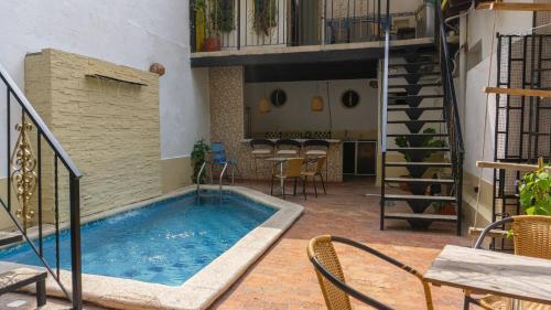 una gran piscina en un patio con una escalera en Maria Mulata Boutique Hotel, en Santa Marta