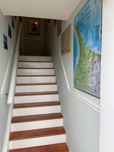 a staircase in a house with a map on the wall at The Jypsy Inn - Journey Apartment Muskoka in Bracebridge