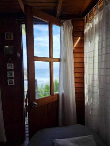 a room with a window and a bed and a door at Coco Ne in Máncora