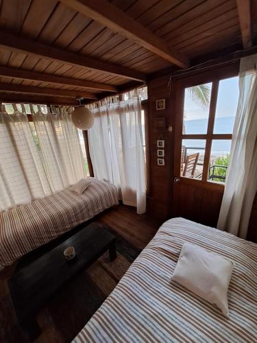 a bedroom with two beds and a window at Coco Ne in Máncora