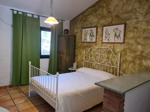 a bedroom with a bed and a stone wall at Apartamentos Rurales Candela in Cañamero