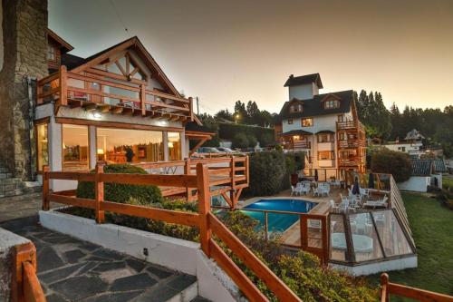 una casa con piscina frente a ella en Apart del Lago en San Carlos de Bariloche