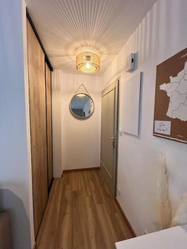 un couloir avec une porte et un miroir mural dans l'établissement Le Phare de la Coubre, à Saint-Martin-de-Ré