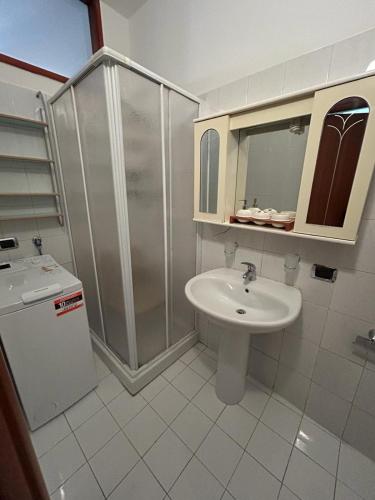 een witte badkamer met een wastafel en een douche bij Casa Vacanze VicoX in Lanciano