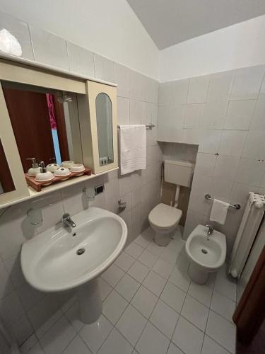 een witte badkamer met een wastafel en een toilet bij Casa Vacanze VicoX in Lanciano