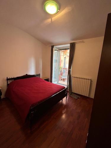 een slaapkamer met een rood bed en een raam bij Casa Vacanze VicoX in Lanciano