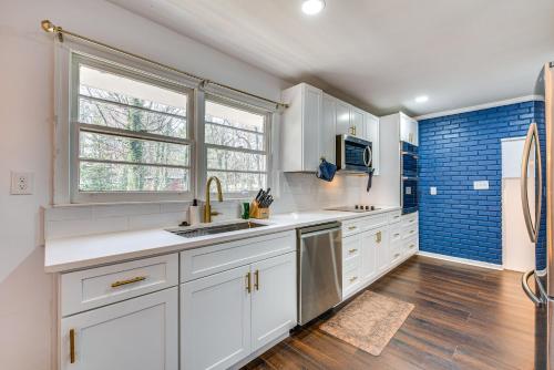 a kitchen with white cabinets and a window at Charming Atlanta Home with Yard 7 Mi to Downtown! in Atlanta