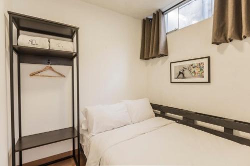 a small bedroom with a bed and a window at Stylish 2BR at Malecon in Lima