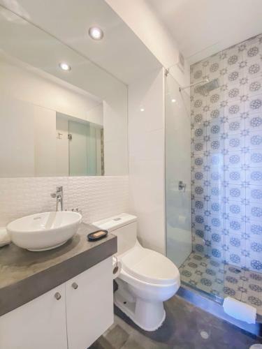 a bathroom with a toilet and a sink and a shower at Stylish 2BR at Malecon in Lima