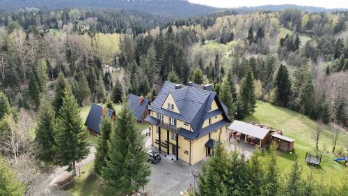 an aerial view of a large house in the woods at Domki Bieszczady Siedlisko Harenda in Czarna
